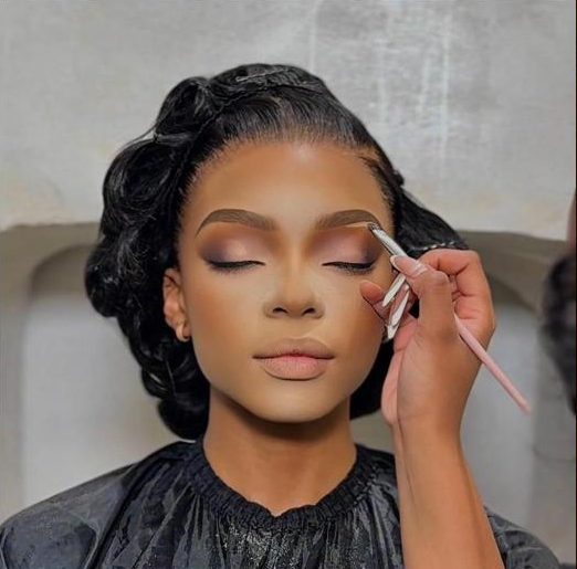 Makeup artist applying bridal glam with a sculpted updo